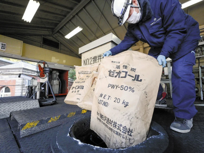 水道水の原水に活性炭を投入する京都市職員