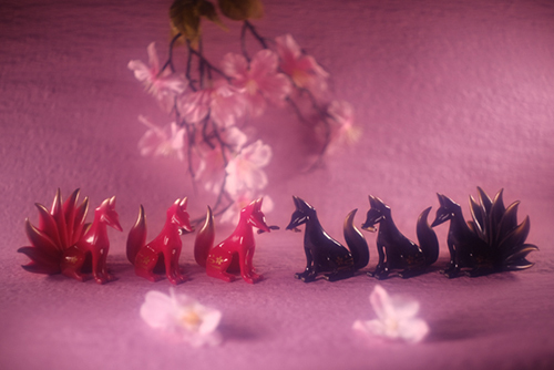 ツバキアキラが撮った、ガチャガチャ、SO-TA・狛狐。桜の中に並ぶ、赤と黒の狛狐たち。